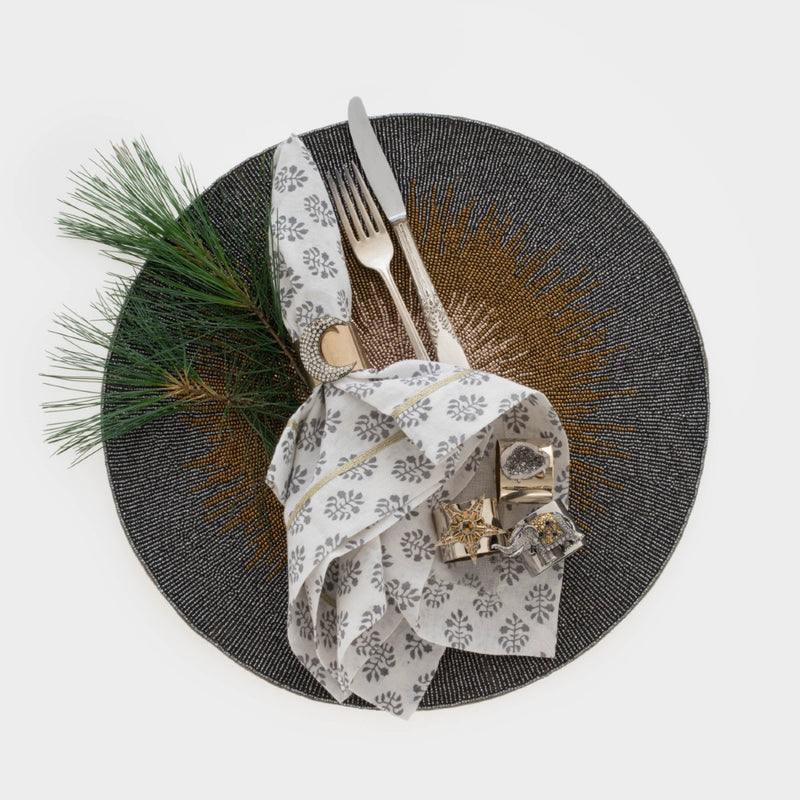 Moon napkin ring in brass gold by Joanna Buchanan, styled with a linen napkin.