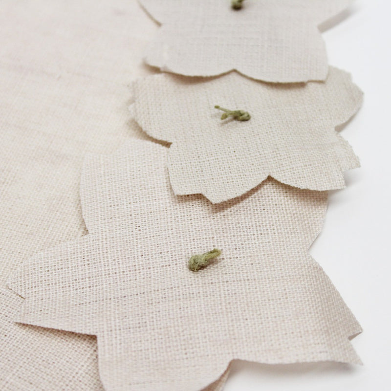 Light pink linen placemat with 3D cherry blossom appliqué by Giardino Segreto close-up.