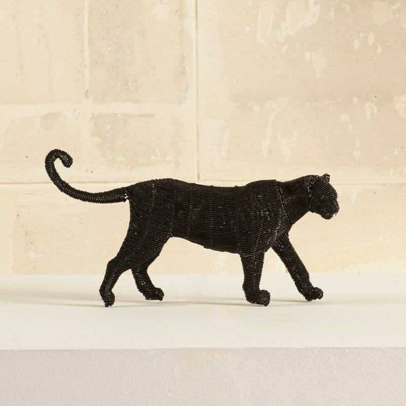 black cheetah figurine on a beige background
