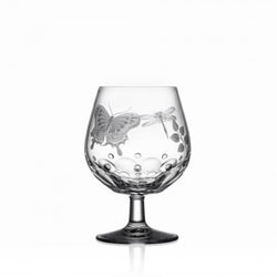 A clear brandy glass with hand-engraved springtime creatures and a flat cut base, showcasing the Varga Art Crystal design.