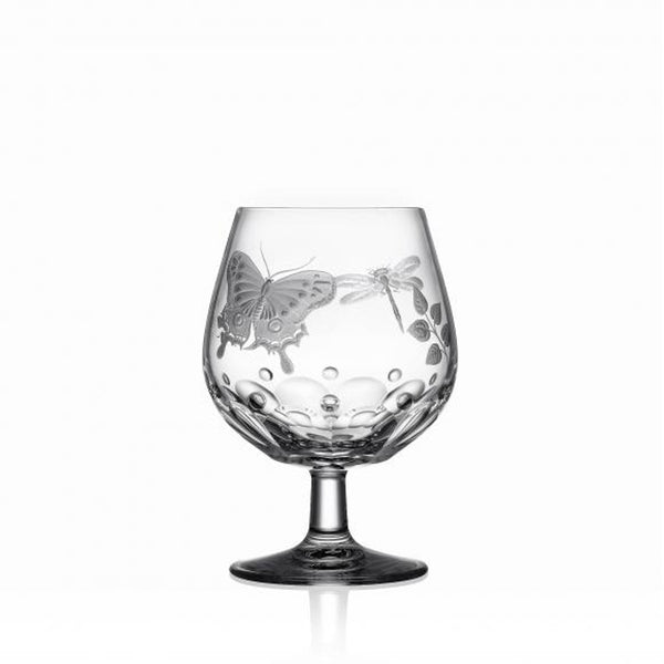 A clear brandy glass with hand-engraved springtime creatures and a flat cut base, showcasing the Varga Art Crystal design.
