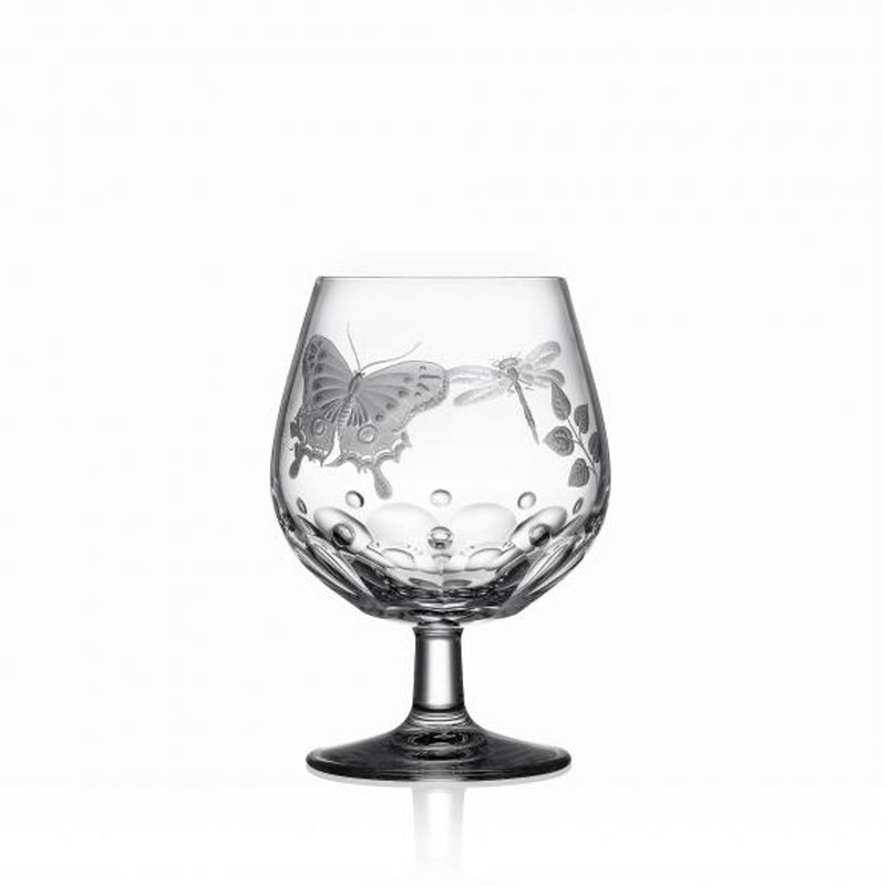 A clear brandy glass with hand-engraved springtime creatures and a flat cut base, showcasing the Varga Art Crystal design.