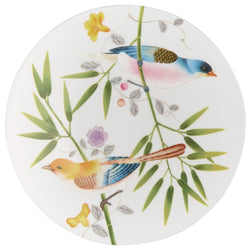A white porcelain dessert plate with a floral motif including birds and leaves.
