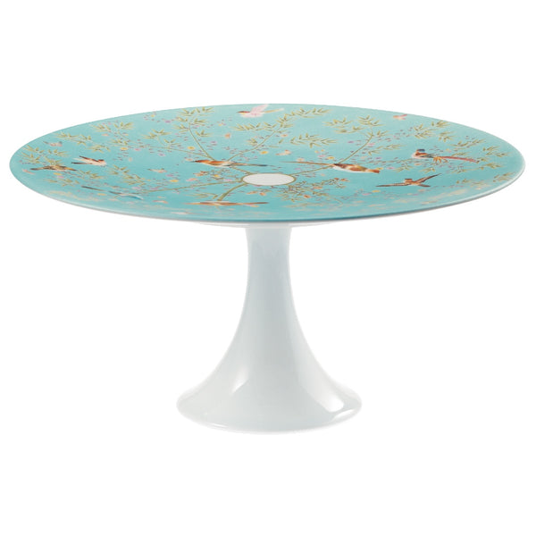 A round porcelain cake stand with turquoise and white colors, featuring floral and bird patterns, and a white base.