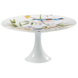 A white porcelain cake stand with a floral pattern and birds of paradise motif, featuring a turquoise edge.