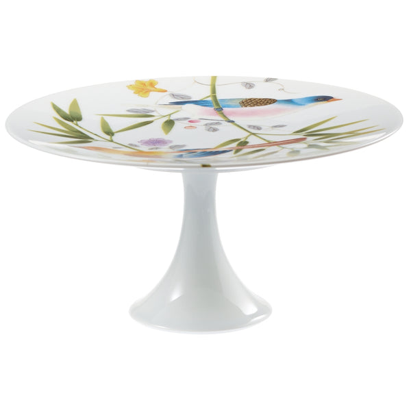 A white porcelain cake stand with a floral pattern and birds of paradise motif, featuring a turquoise edge.
