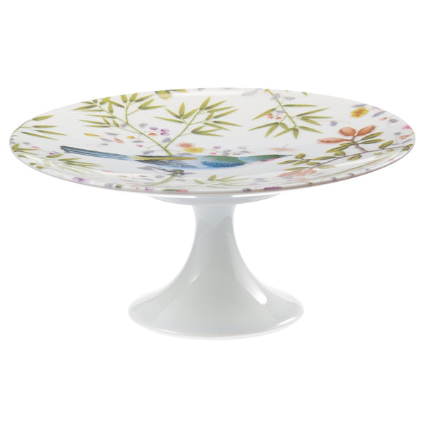 A small white porcelain cake stand with a floral pattern and green accents, featuring birds and plants.