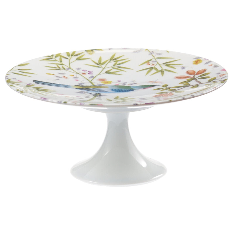 A small white porcelain cake stand with a floral pattern and green accents, featuring birds and plants.