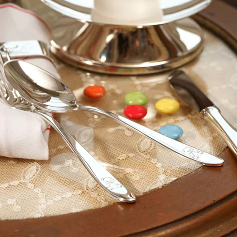 Styled table with Silver-plated 3-piece children’s cutlery set with engraved teddy bear motif by Sonja Quandt.