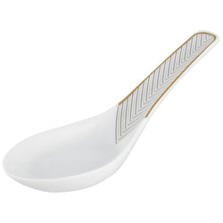 A white porcelain spoon with gold and black geometric patterns on the handle.
