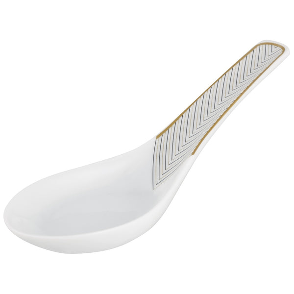 A white porcelain spoon with gold and black geometric patterns on the handle.