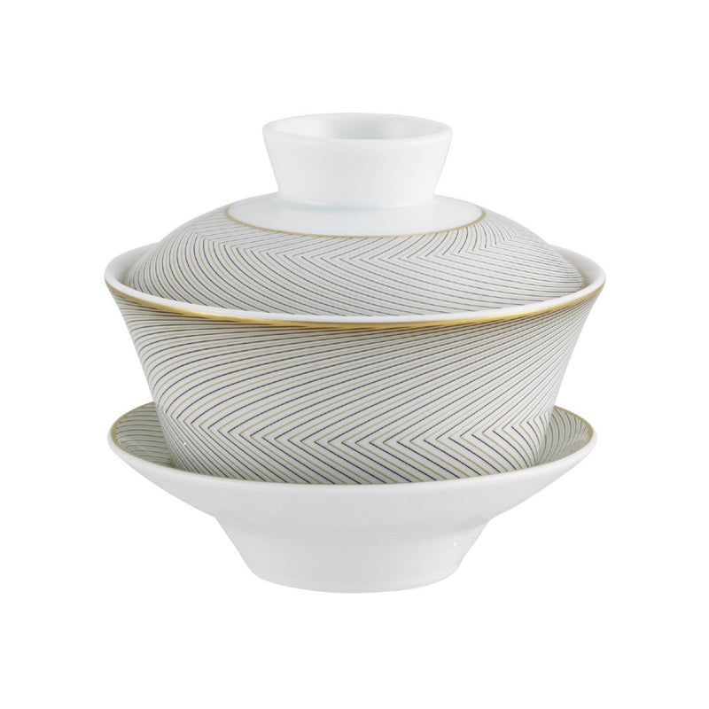 A Raynaud porcelain tea set with black and gold geometric patterns on a white background, including a taller cup and a shorter bowl.