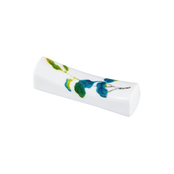 A white porcelain chopstick rest featuring a floral pattern with blue and green colors, representing the 'Harmonia' dinnerware collection by Raynaud.