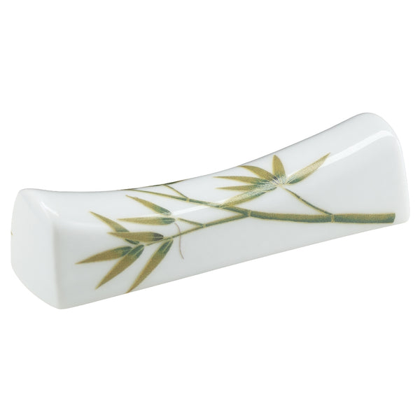 A white porcelain chopstick rest with turquoise and green leaf patterns.
