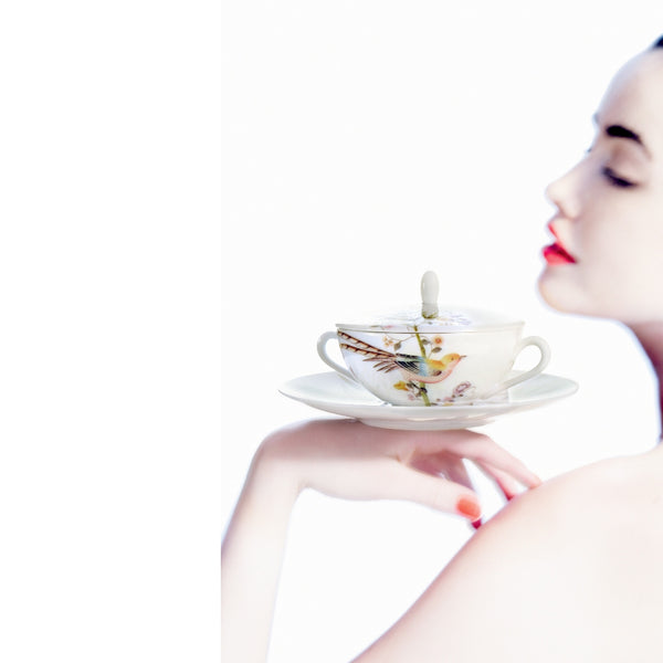 white soup bowl with lid and saucer hold by a lady