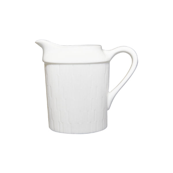 A white porcelain creamer with a pouring spout and handle, featuring a subtle textured pattern.