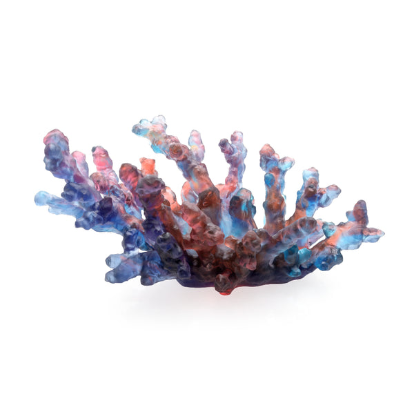 A sculpted crystal coral bowl in blue and amber colors with a solid pattern and no visible base.