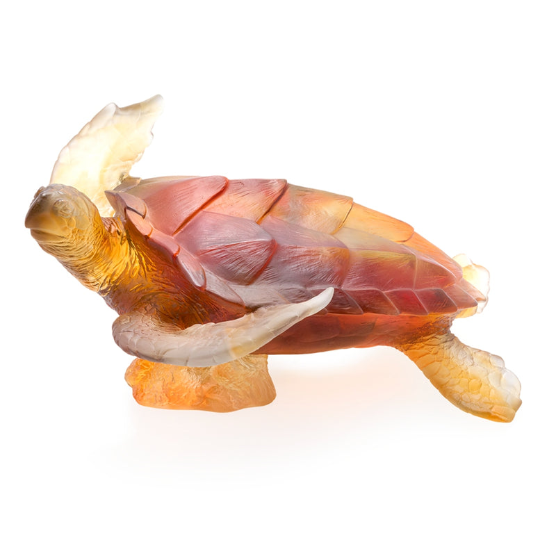 A large crystal sculpture of a sea turtle in amber and gray colors showing from the side