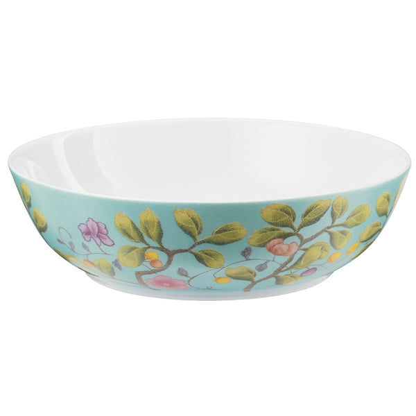 A turquoise and white porcelain dinner plate with a floral and botanical pattern, part of the 'Paradis' collection by Raynaud.