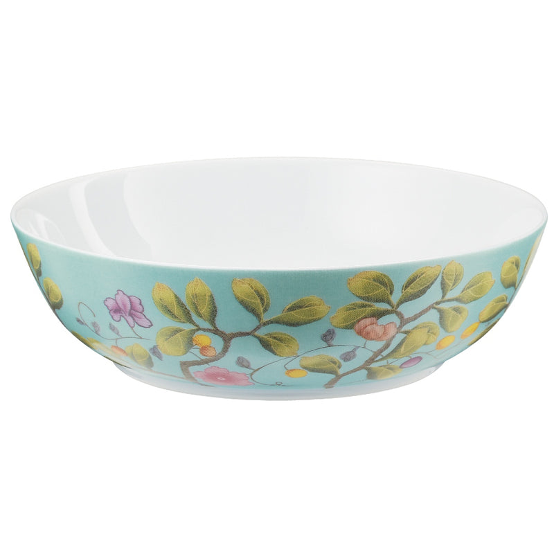 A turquoise and white porcelain dinner plate with a floral and botanical pattern, part of the 'Paradis' collection by Raynaud.