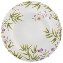 A white porcelain deep plate with green and brown floral patterns.