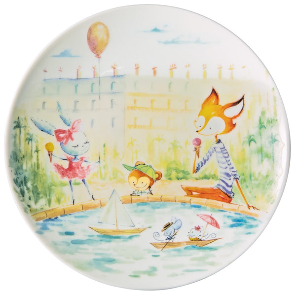 A colorful porcelain dessert plate from Raynaud featuring hand-painted characters including hares, mice, and a fox, with a background that includes the Eiffel Tower and Notre Dame Cathedral.