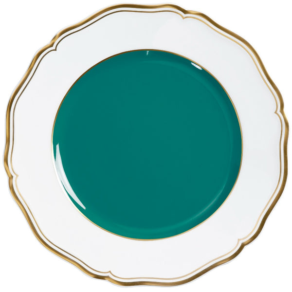 A round porcelain dessert plate with a scalloped edge and gold detailing, featuring a turquoise center.