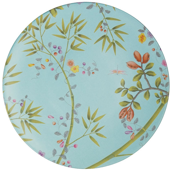 A turquoise porcelain dinner plate with floral and animal patterns, including bamboo, leaves, and butterflies.