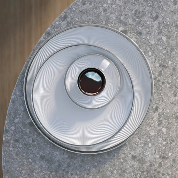 styled espresso cup and saucer on top of plates with platinum rim