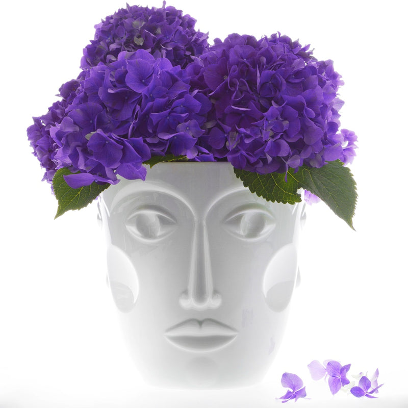 white vase featuring a womans face with purple flowers