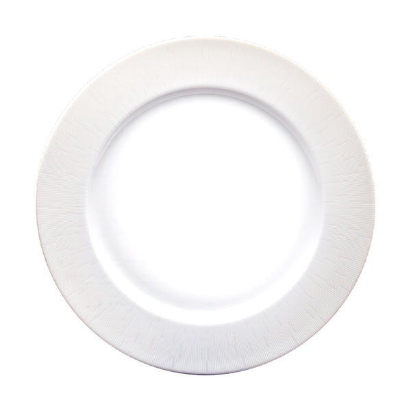 A flat, white, round porcelain dish with a simple, elegant engraved pattern.
