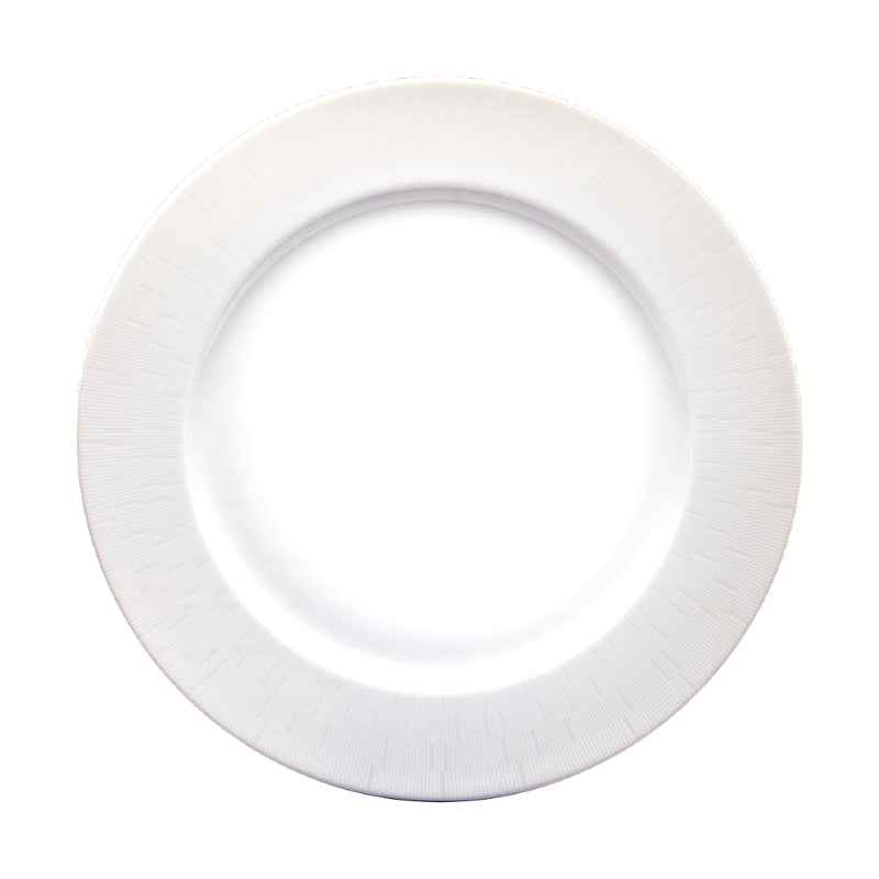 A flat, white, round porcelain dish with a simple, elegant engraved pattern.