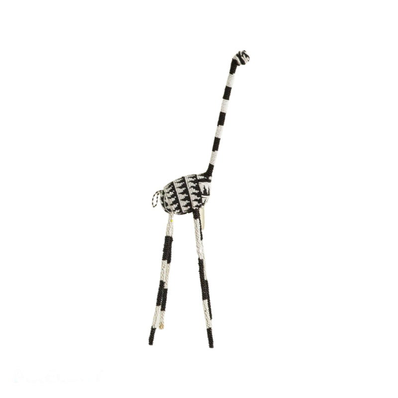 A decorative giraffe sculpture with a black and white color scheme, featuring traditional wire and glass beadwork.