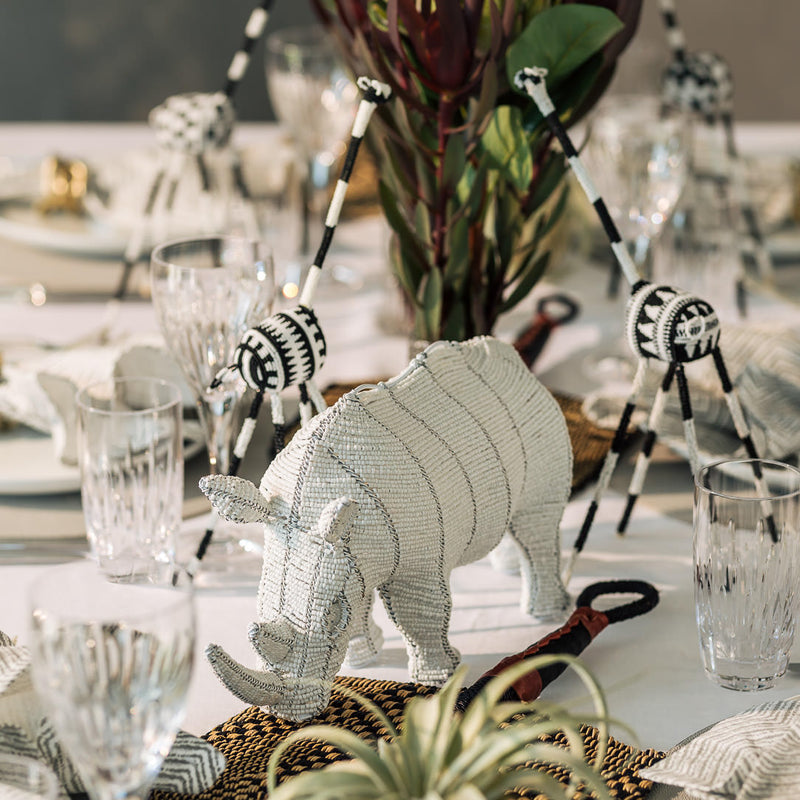 table decor featuring 2 black and white giraffes and a white rhino made from beads as safari theme table decor