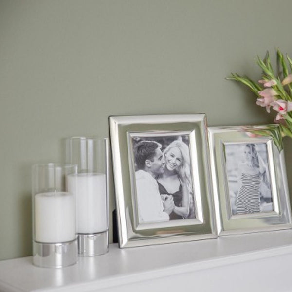 styled counter with photo frames and Granada hurricane lamp candle holders by Edzard with silver base and glass cylinder