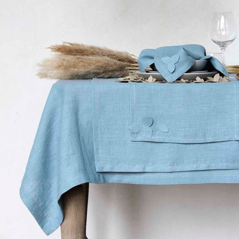 table decorated with blue runner and tablecloth featuring applied fabric flowers