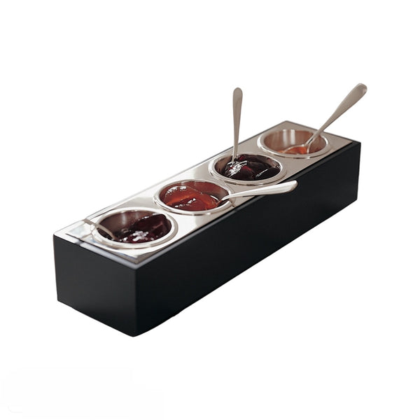 A silver-plated, black Corian jam and sugar bar with four compartments, featuring removable inserts for jams or sugar, with teaspoons resting on the edge.
