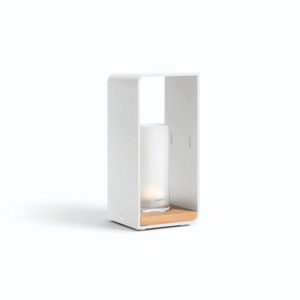 A medium-sized white outdoor lantern with a clear glass tube and a wooden base, designed by Manutti.