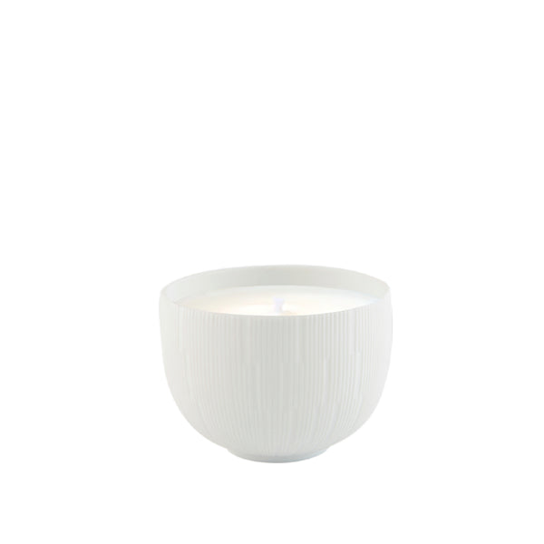 A white porcelain candle holder with a candle inside, on a plain background.