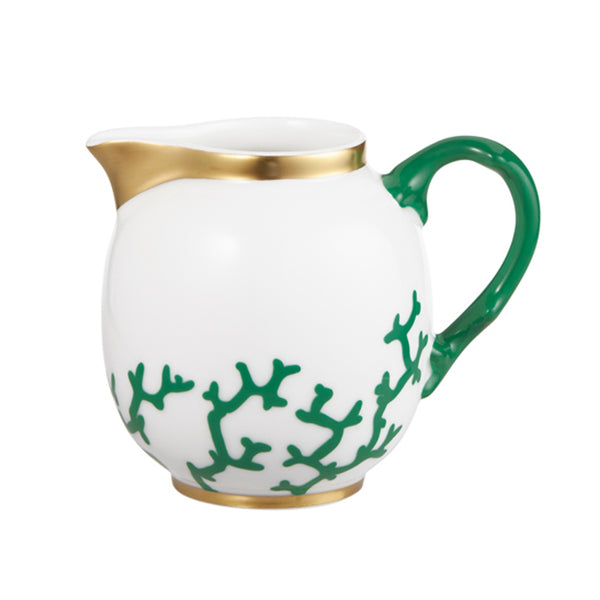 A white porcelain milk jug with gold-plated handle and green coral branches patterns on the side.