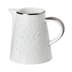 A white porcelain milk jug with platinum detailing on the rim and handle, and a textured surface.