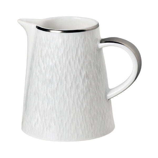 A white porcelain milk jug with platinum detailing on the rim and handle, and a textured surface.