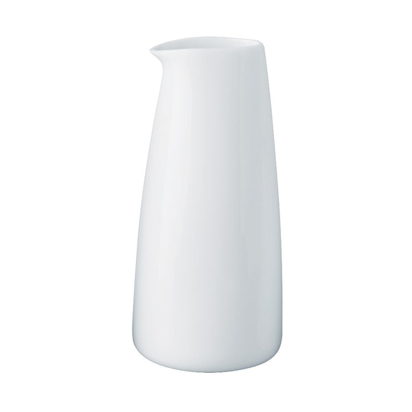 A white, porcelain milk pot with a wide rim and a spout on the side, against a plain background.