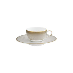 A white porcelain Moka cup with a gold handle and brown geometric pattern on the side, accompanied by a matching saucer.