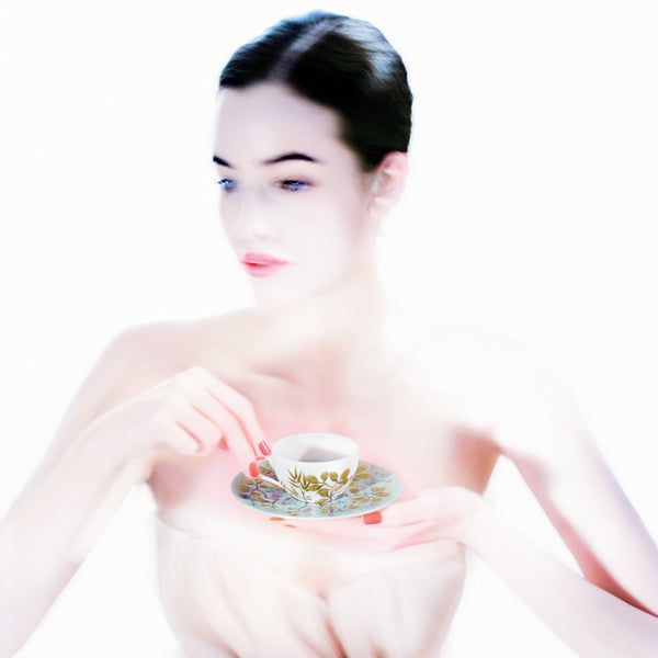 woman holding a moka cup with floral design