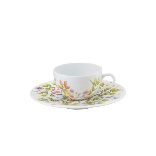 A white porcelain Moka cup with turquoise and brown floral patterns on the cup and saucer.