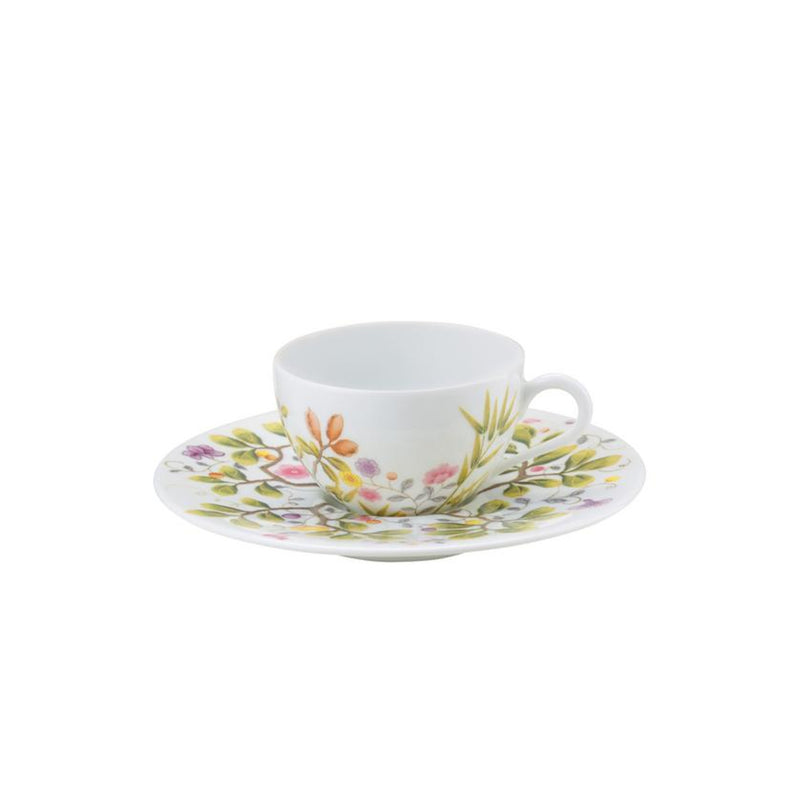 A white porcelain Moka cup with turquoise and brown floral patterns on the cup and saucer.