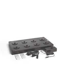 A black multi charger with an EU power plug and two remote controls for Flame Lumo and Sandua Lanterns, against a white background.
