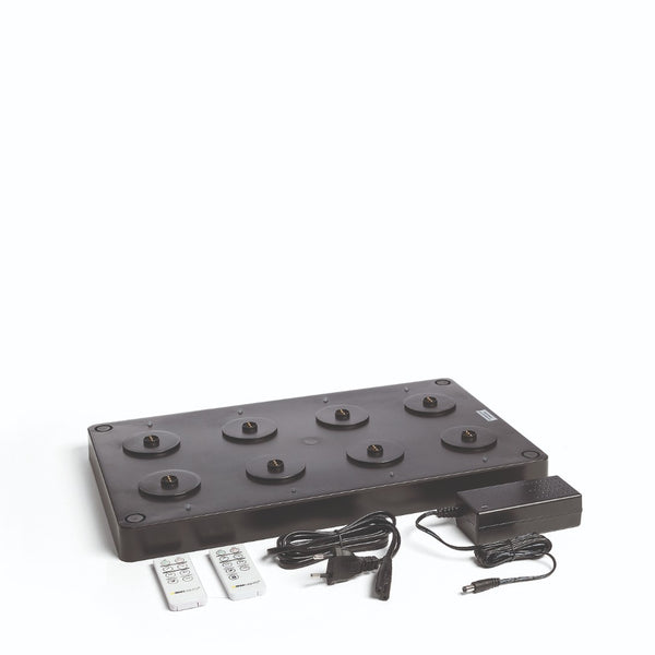 A black multi charger with an EU power plug and two remote controls for Flame Lumo and Sandua Lanterns, against a white background.