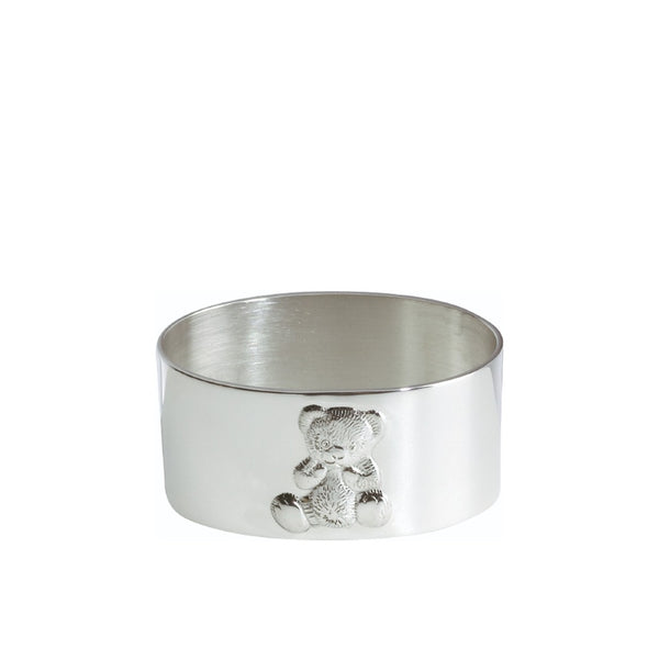 silver-plated napkin ring with engraved teddy bear motif by Sonja Quandt on white linen napkin